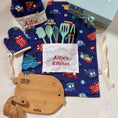 Load image into Gallery viewer, Children's kitchen set with apron, utensils, and cutting board on a blue background with vehicle pattern.