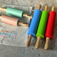 Load image into Gallery viewer, Set of colorful silicone rolling pins with wooden handles on a countertop.