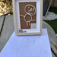 Load image into Gallery viewer, Framed drawing of a child with 'Zara 5 Years old' text, placed on a surface outdoors.

