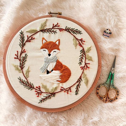 Hand embroidered fox in a scarf inside a winter berry and pine wreath hoop, custom made in Dubai