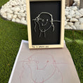Load image into Gallery viewer, Child's drawing of a person on a blackboard with 'Taj 3 years old' written below, placed on grass.
