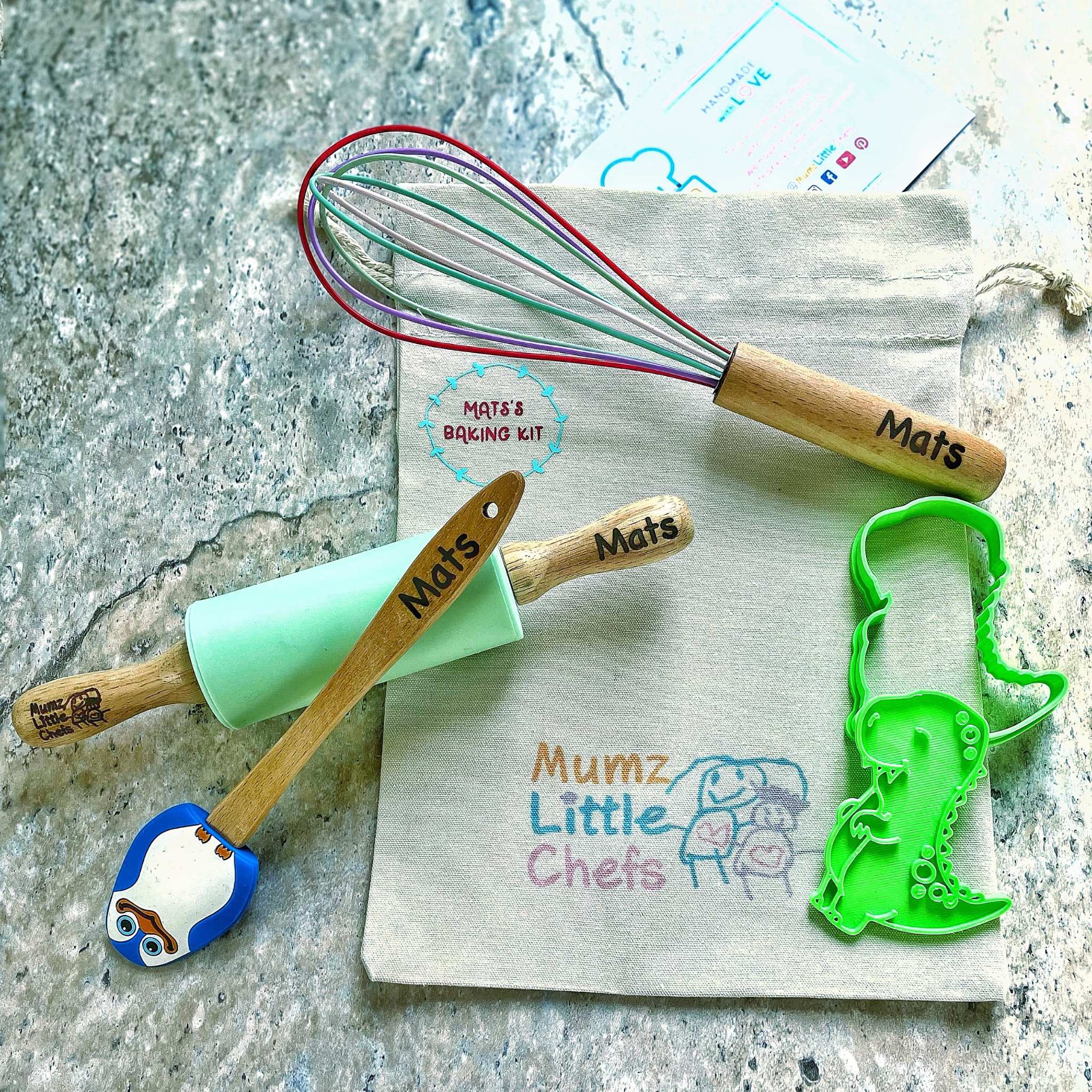 Baking tools with 'Mats' and 'Mumz Little Chefs' branding on a textured surface.