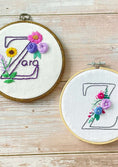Load image into Gallery viewer, Two embroidery hoops with floral letter 'Z' designs on a wooden surface
