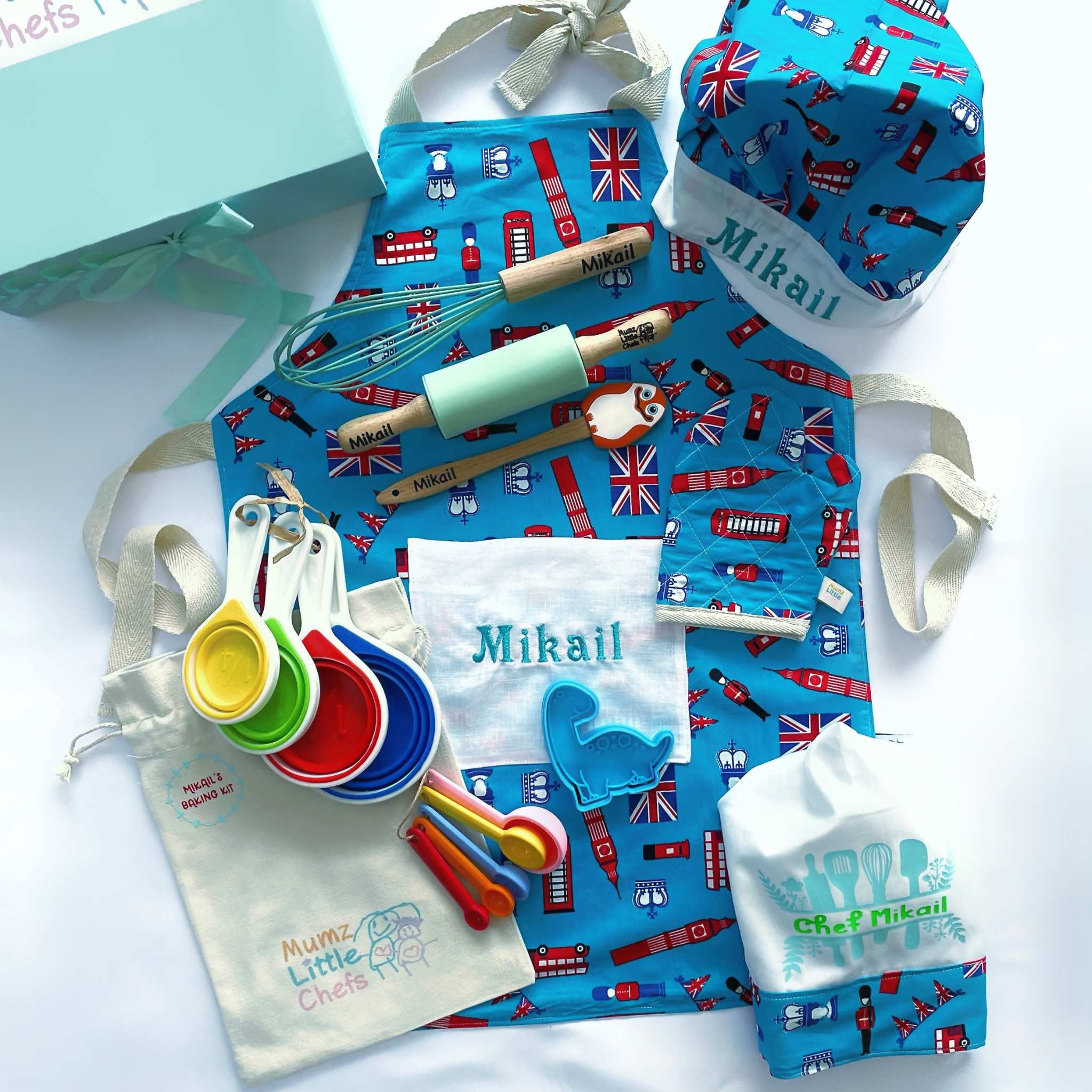 Children's cooking set with apron, hat, and utensils featuring British-themed design.