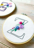 Load image into Gallery viewer, Embroidery hoops with floral designs on a wooden surface
