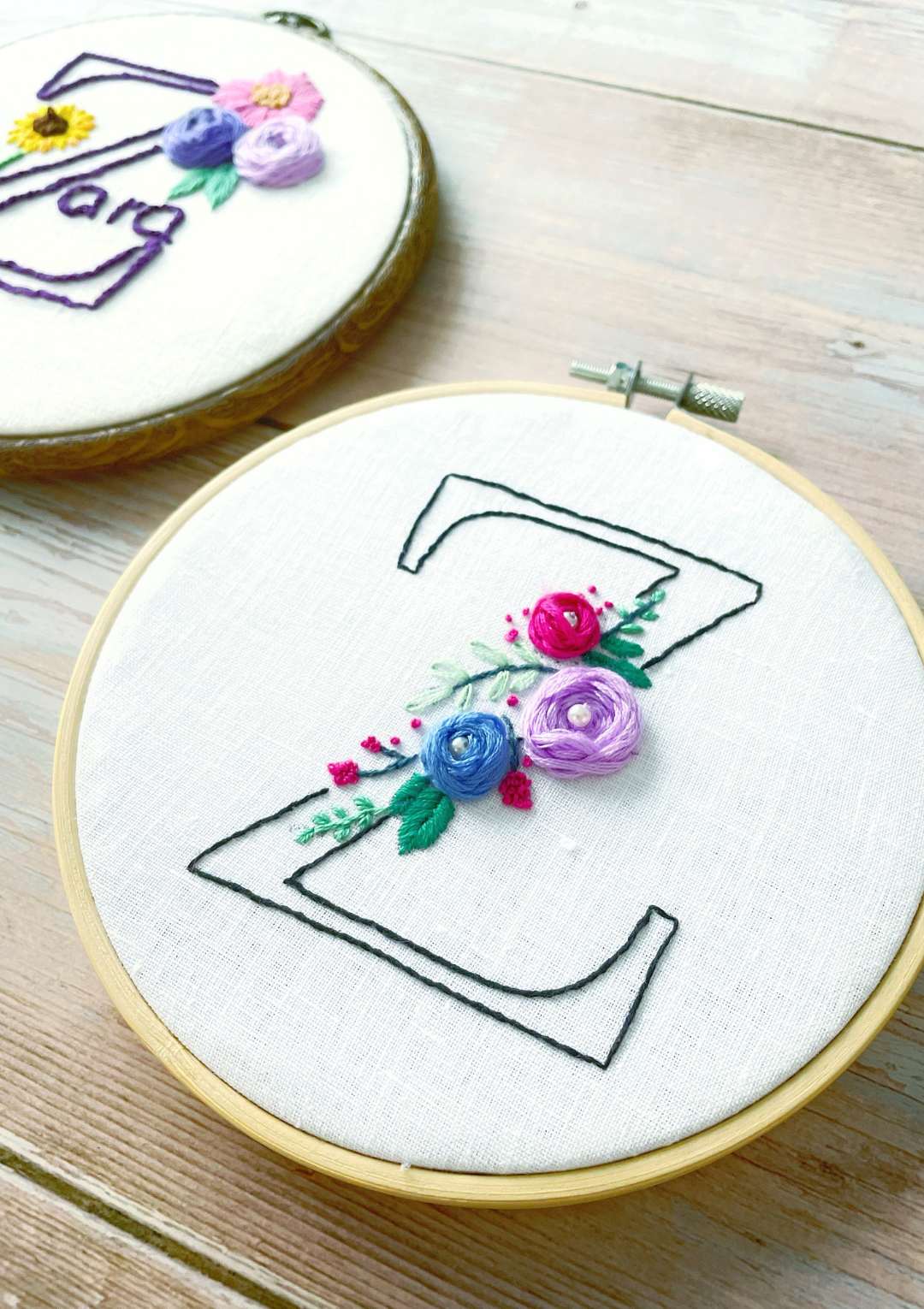 Embroidery hoops with floral designs on a wooden surface